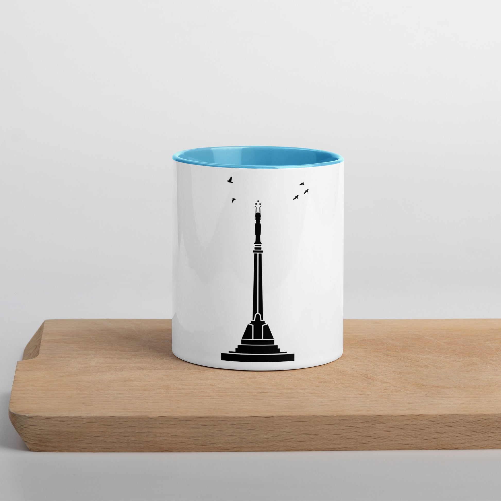 white coffee mug with blue inside featuring Riga's Liberty Monument